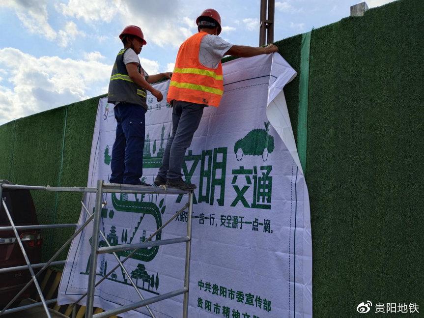 机电1标员工在七机路口站张贴文明宣传画